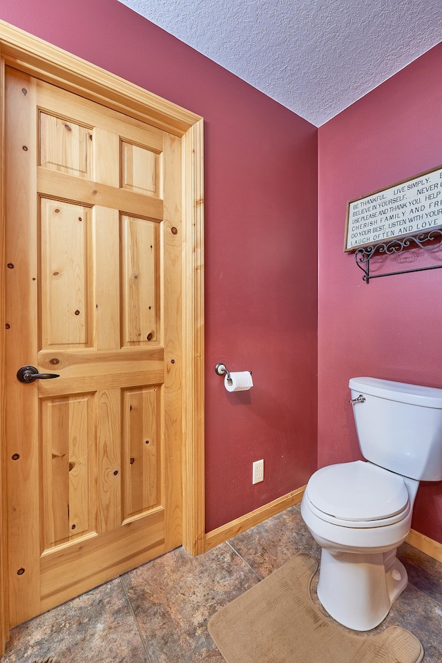 bathroom featuring a textured ceiling and toilet