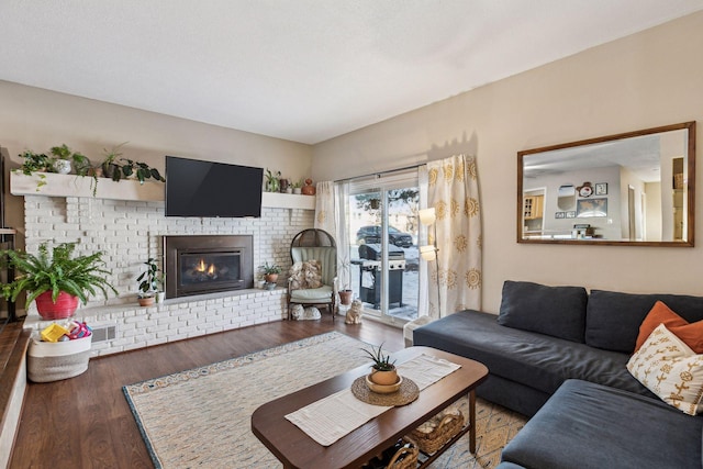 living room featuring a brick fireplace and dark hardwood / wood-style floors