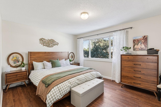 bedroom featuring dark wood-type flooring and a textured ceiling