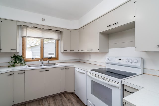 kitchen featuring dark hardwood / wood-style flooring, sink, white appliances, and white cabinetry