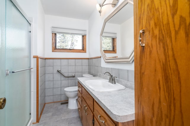 bathroom featuring tile walls, vanity, toilet, and an enclosed shower