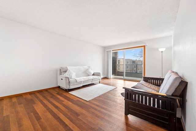 living room featuring wood-type flooring and a textured ceiling