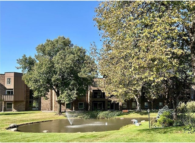 exterior space with a water view and a front lawn