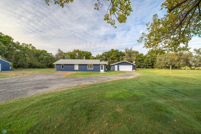 ranch-style house with a garage, an outdoor structure, and a front lawn