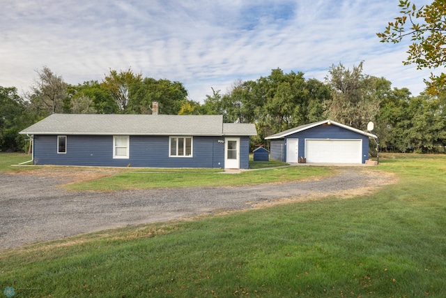 ranch-style home with an outdoor structure, a garage, and a front lawn