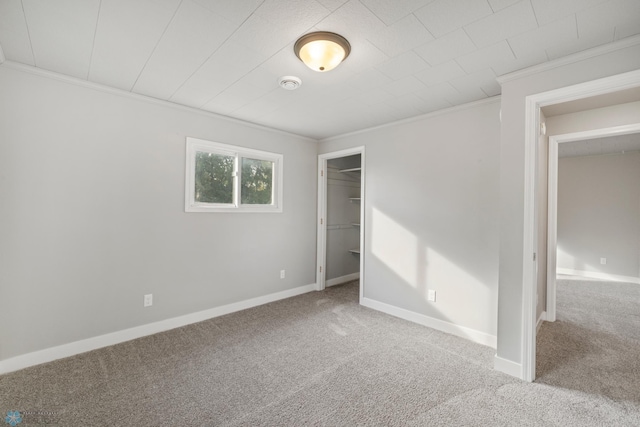 unfurnished bedroom featuring a closet, crown molding, and carpet flooring