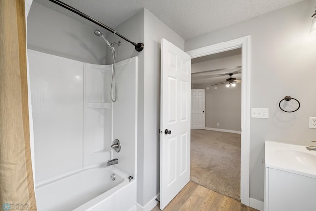 bathroom with vanity, a textured ceiling, ceiling fan, shower / bathing tub combination, and hardwood / wood-style flooring