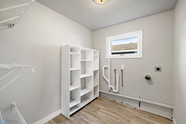 washroom featuring light hardwood / wood-style flooring and hookup for an electric dryer