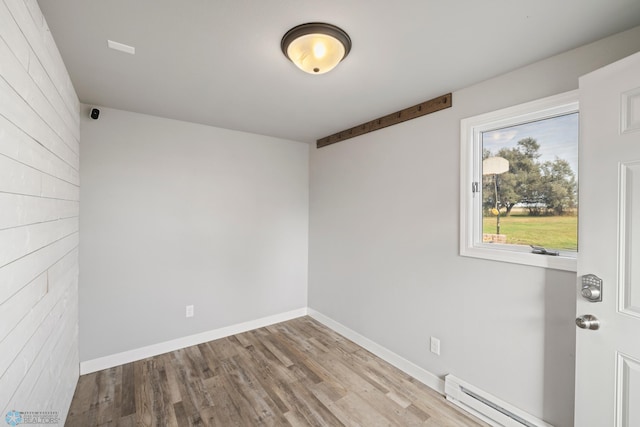 empty room featuring light hardwood / wood-style floors and baseboard heating