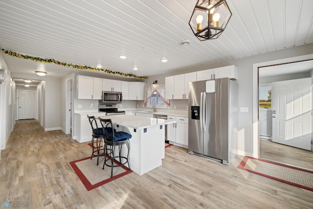 kitchen with light hardwood / wood-style flooring, stainless steel appliances, a center island, and white cabinetry