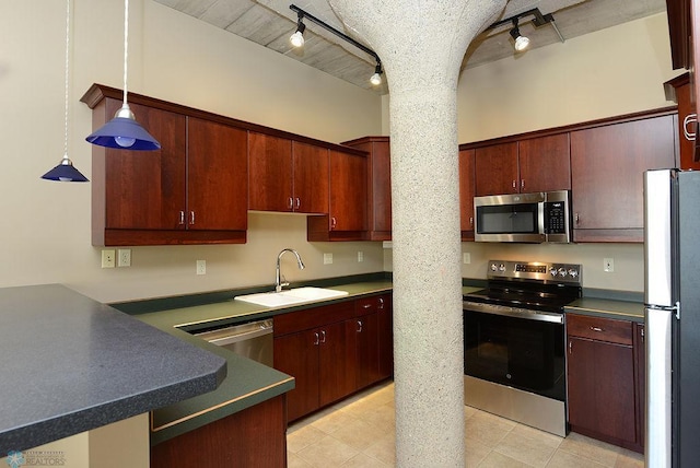 kitchen featuring appliances with stainless steel finishes, light tile patterned floors, track lighting, decorative light fixtures, and sink