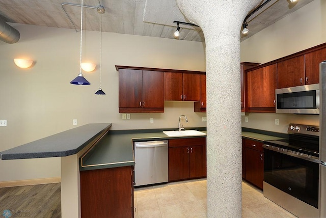 kitchen featuring pendant lighting, light hardwood / wood-style floors, track lighting, sink, and stainless steel appliances