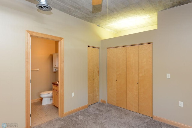 unfurnished bedroom featuring connected bathroom, ceiling fan, and light colored carpet