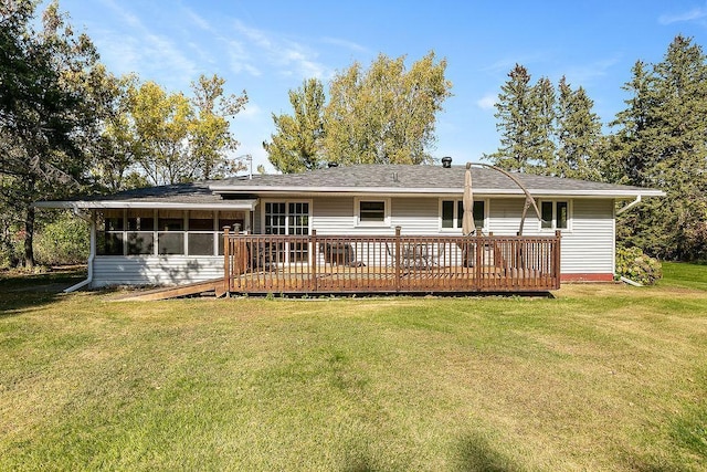 rear view of property with a wooden deck, a lawn, and a sunroom