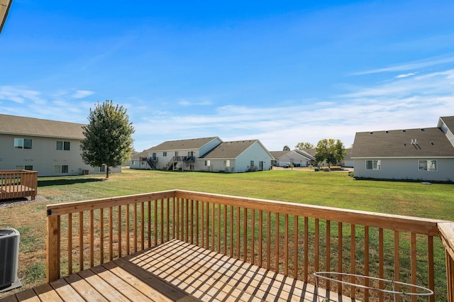 wooden terrace featuring central AC, a lawn, and a residential view