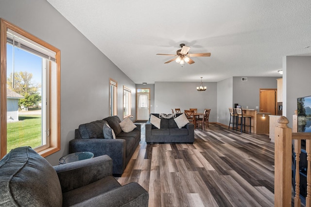 living area with visible vents, baseboards, wood finished floors, a textured ceiling, and ceiling fan with notable chandelier