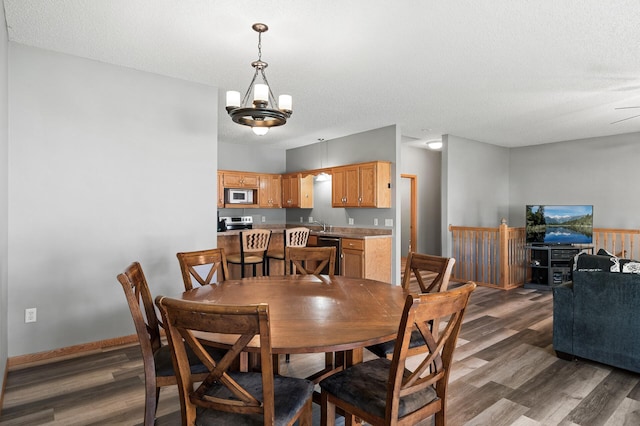 dining space with a textured ceiling, dark wood finished floors, and baseboards