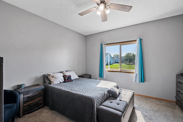 bedroom featuring light carpet, ceiling fan, a textured ceiling, and baseboards