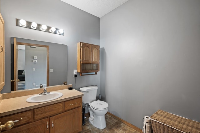 bathroom featuring vanity, toilet, and baseboards