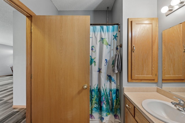 bathroom featuring wood finished floors, a textured ceiling, and vanity