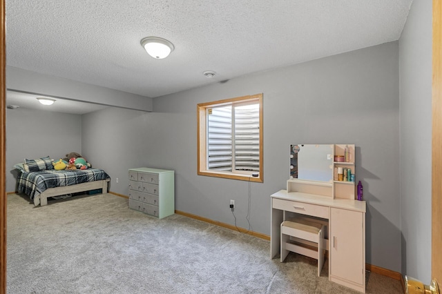 carpeted bedroom featuring a textured ceiling and baseboards