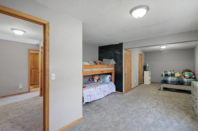 carpeted bedroom featuring a textured ceiling and baseboards