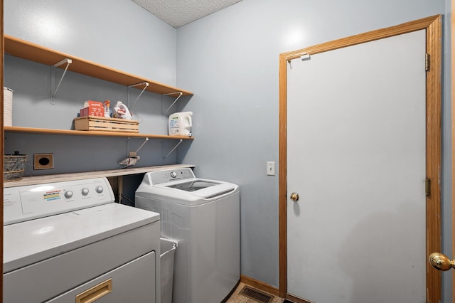 clothes washing area featuring laundry area, visible vents, and washing machine and clothes dryer