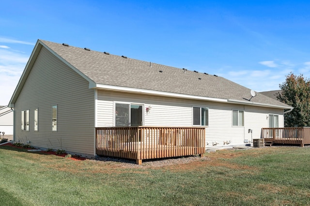 back of property featuring a shingled roof, a lawn, and a wooden deck