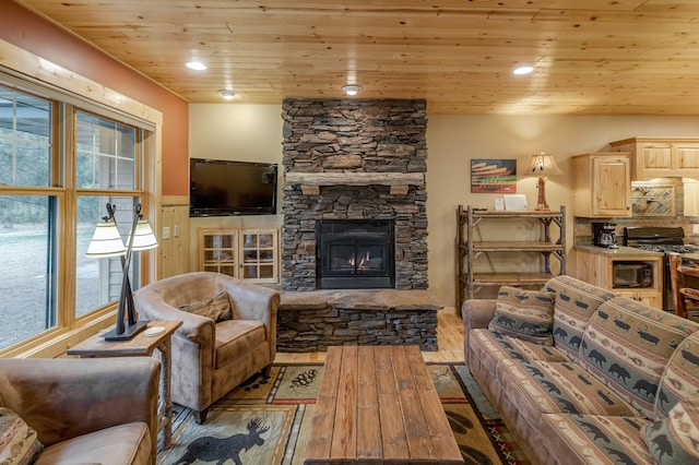 living room featuring a stone fireplace, wood ceiling, light hardwood / wood-style flooring, and plenty of natural light