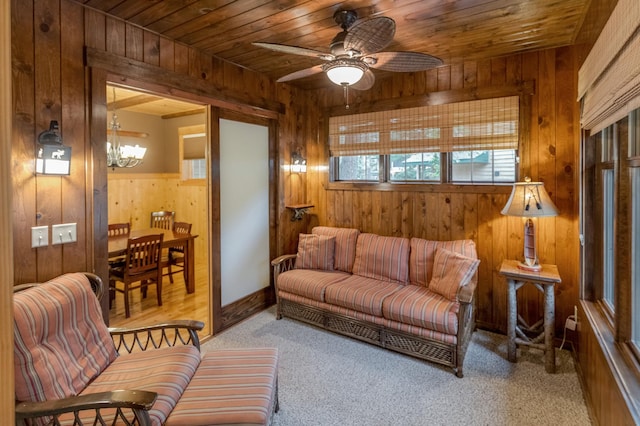 living room featuring wooden ceiling, wooden walls, ceiling fan, and light colored carpet