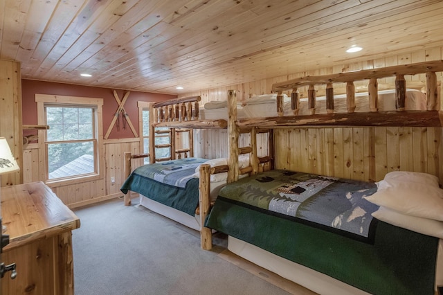 carpeted bedroom with wood ceiling and wooden walls