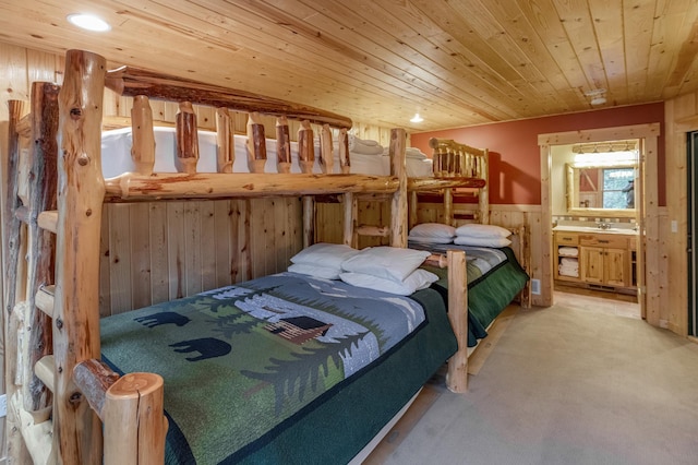 bedroom with wood ceiling, wood walls, carpet floors, and ensuite bathroom