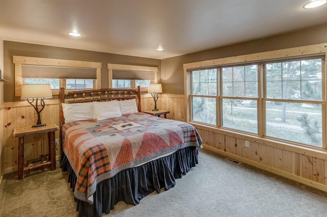 carpeted bedroom with wooden walls