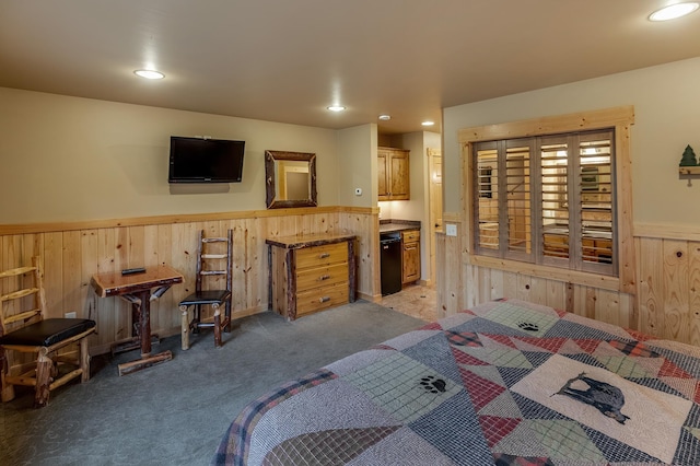 carpeted bedroom with connected bathroom and wood walls