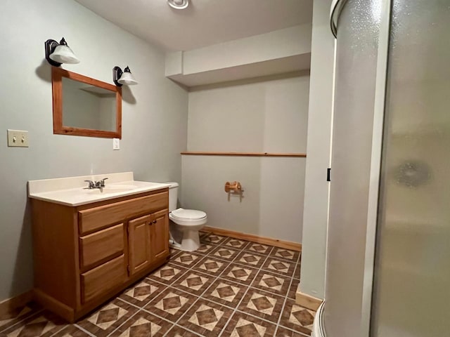 bathroom with vanity, tile patterned flooring, toilet, and a shower with door