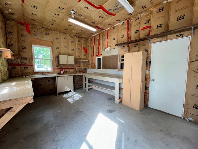 miscellaneous room with a workshop area and concrete floors