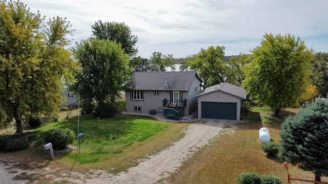 view of front of property featuring an outdoor structure, a garage, and a front lawn