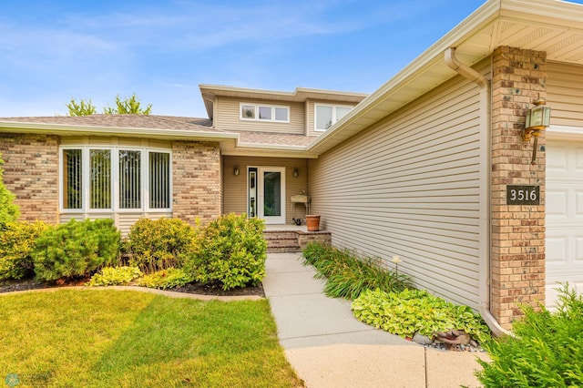 entrance to property with a lawn and a garage