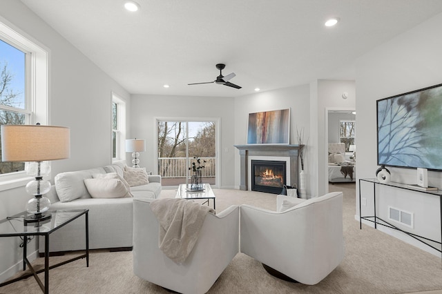 carpeted living room with ceiling fan