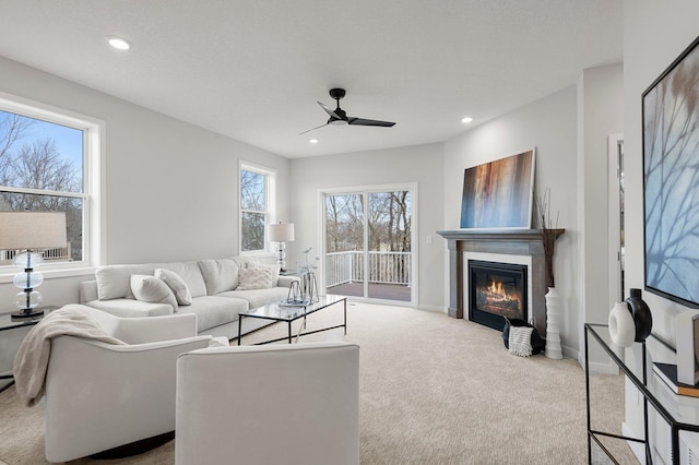 carpeted living room with ceiling fan