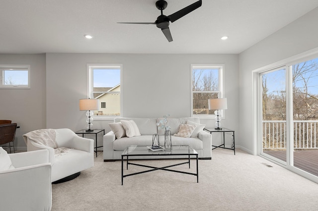 living room with light carpet, ceiling fan, and a healthy amount of sunlight