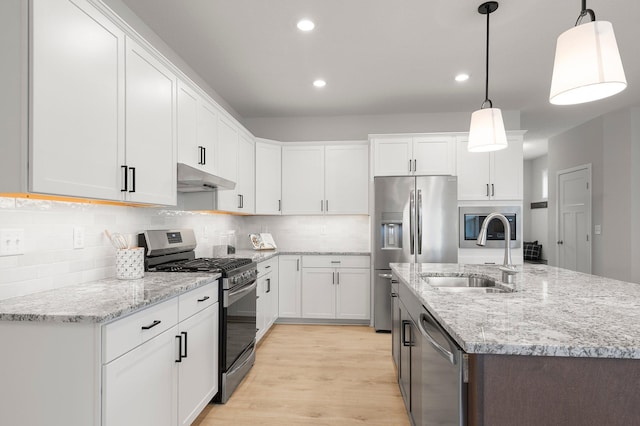 kitchen with decorative light fixtures, appliances with stainless steel finishes, sink, and white cabinetry