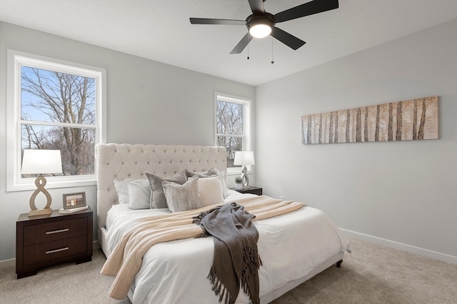 bedroom featuring light carpet, multiple windows, and ceiling fan