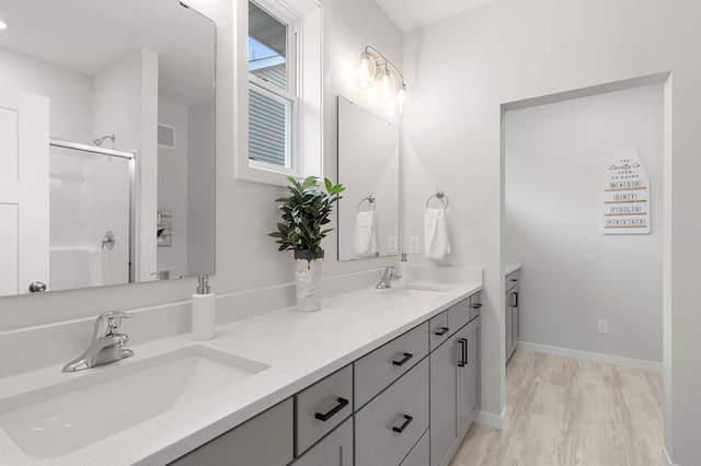 bathroom featuring hardwood / wood-style floors, walk in shower, and vanity