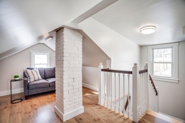 additional living space with ornate columns, vaulted ceiling, baseboards, and wood finished floors