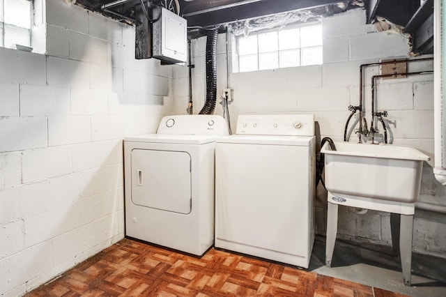 washroom with laundry area, washer and clothes dryer, and a sink