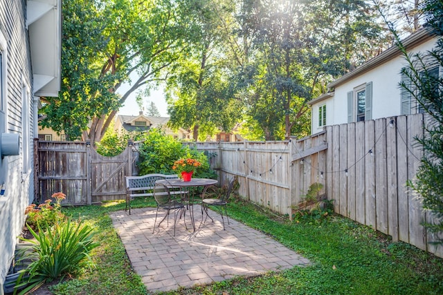 view of yard featuring a gate, a patio area, and a fenced backyard