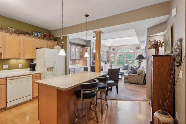 kitchen featuring decorative light fixtures, ornate columns, light brown cabinets, white appliances, and light hardwood / wood-style flooring