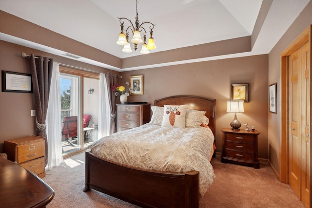 bedroom with a tray ceiling, access to outside, a chandelier, and light colored carpet