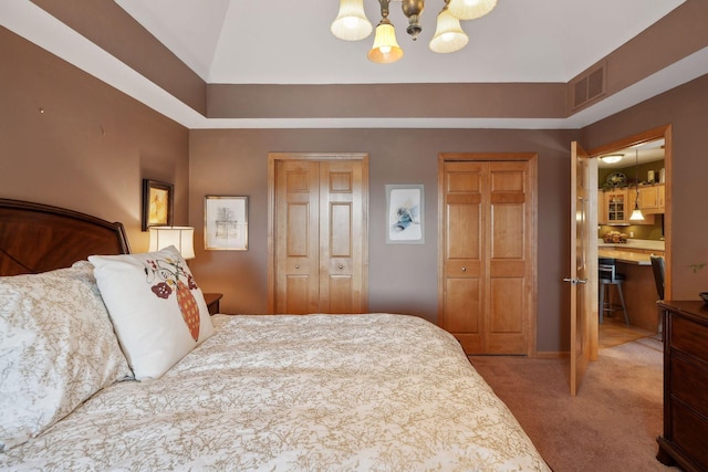 carpeted bedroom with a closet and a notable chandelier